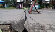 A motorcyclist rides around an asphalt road, which was damaged after a 6.5-magnitude earthquake struck overnight, in Surigao City in southern island of Mindanao on February 11, 2017. Rescuers dug through rubble on February 11 to find survivors after a pow
