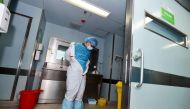 This photo taken on February 12, 2017 shows a member of staff taking off his decontamination suit after treating a H7N9 bird flu patient in a hospital in Wuhan, central China's Hubei province. / AFP / STR
