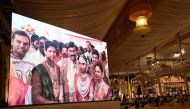 Indian mining tycoon, Gali Janardhan Reddy, (C) on a big screen as he poses with his daughter Bramhani (2R) and son-in-law, Rajeev Reddy (2L) during their wedding at the Bangalore Palace Grounds in Bangalore on November 16, 2016 AFP