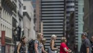 Shoppers carry bags while crossing Post Street in San Francisco. 