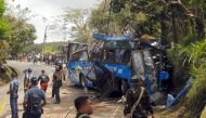 Police and soldiers stand guard next to a tourist bus which hit an electric post in Tanay town, Rizal province, east of Manila on February 20, 2017. AFP / STR
