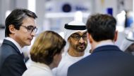 Crown Prince of Abu Dhabi Sheikh Mohammed bin Zayed al-Nahyan (C) stands next to Patrice Caine (L), CEO of French multinational company Thales, in a showroom during the opening of the International Defence Exhibition and Conference (IDEX) in the Emirati c