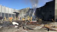 This handout photo released by the Metropolitan Fire Brigade (MFB) media shows firemen putting out a blaze from a light aircraft which exploded as it smashed into a shopping centre near Melbourne on February 21, 2017. AFP / METROPOLITAN FIRE BRIGADE MEDIA