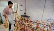 An employee works on a rack of slaughtered ducks at a poultry farm in Eugenie les Bains, France, January 24, 2017, as France scales back preventive slaughtering of ducks to counter bird flu after the culling of 800,000 birds this month helped slow the spr