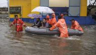 Flood-affected residents use a rubber boat in an inundated neighbourhood in Jakarta on February 21, 2017. Jakarta was hit by widespread flooding on February 21 after hours of torrential rain, with thousands of homes inundated, cars stranded and people for