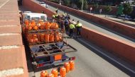 Police officers stand next to a butane gas delivery truck against which police had to shoot to stop it in Barcelona on February 21, 2017. Spanish police said today they fired on a truck loaded with butane gas bottles which was driving the wrong way down a