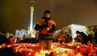 Remembering a revolution: A man holds a candle as he commemorates the third anniversary of Ukrainian mass protests in 2014 that sparked a revolution, in central Kiev, yesterday.