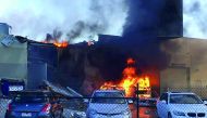 Smoke and flames seen after a twin-engined Beechcraft plane crashed into a shopping centre just after take-off from Essendon Fields Airport near Melbourne, yesterday.