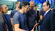 French President Francois Hollande (right) talks to workers as he visits the turbines production unit of the General Electric plant in Belfort
