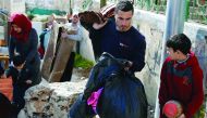 A Palestinian man gathers his belongings outside his house that was demolished by Israeli army bulldozers in the Arab East Jerusalem, yesterday.
