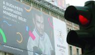 Traffic lights switch to red in front of a Hungarian pro-Olympics billboard with two-times sabre fencing Olympic champion Aron Szilagyi advertising the Games, billboard saying 