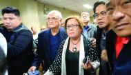 Philippine Senator Leila de Lima is escorted by the security personnel, at the Senate headquarters in Pasay City, yesterday.