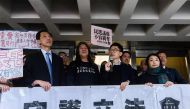Elected pro-democracy lawmakers (L-R) Edward Yiu, (Long Hair) Leung Kwok-hung, Nathan Law, and Lau Siu-lai hold a banner outside the High Court before facing a judicial review into whether they should be disqualified from their Legislative Council seats, 