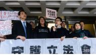 Elected pro-democracy lawmakers (L-R) Edward Yiu, “Long Hair” Leung Kwok-hung, Nathan Law and Lau Siu-lai hold a banner outside the High Court in Hong Kong AFP/Anthony WALLACE.