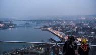 Women stand at a scenic view point overlooking the Golden Horn in Istanbul on February 27, 2017. / AFP / OZAN KOSE