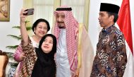 Indonesian President Joko Widodo watches as former president Megawati Sukarnoputri and her daughter Puan Maharani, a minister in his cabinet, take a selfie with King Salman at the Presidential Palace, in Jakarta.