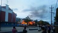 (FILES) This file photo taken on August 31, 2015 shows Indian people watching a blaze at the residence of Manipur state health minister Phungzaphang Tonsimg that was torched during a protest against controversial tribal rights laws, at Churachandpur, some