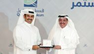 Saad Sherida Al Kaabi, President and CEO of Qatar Petroleum, awards a long-serving employee Ahmad Saif Al Sulaiti, Executive VP, Operations.
