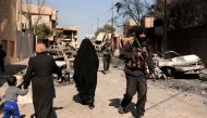 A special forces member walks past displaced Iraqis as they flee their homes in Al Mansour district, while Iraqi forces battle with Islamic State militants, in western Mosul, Iraq March 6, 2017. REUTERS/Zohra Bensemra
