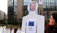 An activist stand near an effigy of European Council President Donald Tusk during a protest calling for migrants' rights as European foreign and defence ministers hold a foreign affairs and defence council at the European Council, in Brussels, on March 6,