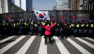 A woman supporting South Korea's ousted leader Park Geun-hye holds the national flag in front of police before the start of a rally supporting Park in Seoul, South Korea, March 11, 2017.REUTERS/Kim Kyung-Hoon 
