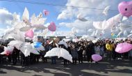 Balloons in the shape of doves are released into the air during a memorial service for victims of the 2011 quake-tsunami disaster in Natori, Miyagi prefecture on March 11, 2017. AFP / KAZUHIRO NOGI