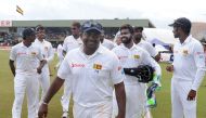 Sri Lankan cricket captain Rangana Herath (C) celebrates with his teammates after victory in the opening Test match between Sri Lanka and Bangladesh at the Galle International Cricket Stadium in Galle on March 11, 2017. (AFP / LAKRUWAN WANNIARACHCHI)