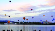 Members of the public watch as balloons participating in the Canberra Balloon Festival fly above the Australian capital city, March 12, 2017. REUTERS/David Gray