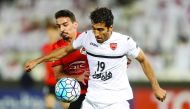 Persepolis' Vahid Amiri (front) fights for the ball during the Asian Champions League football match against Qatar's Al Rayyan at Jassim Bin Hamad Stadium in Doha