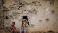 Iraqi boys sit outside their house that was damaged during the fighting between Iraqi forces and Islamic State militants, south of Mosul, Iraq March 15, 2017. REUTERS/Suhaib Salem
