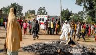 A Muslim woman looks on while standing near the site where four female suicide bombers blew themselves up near a bus station in Maiduguri, northeastern Nigeria on March 15, 2017 killing two people, the country's disaster agency said. AFP / STRINGER