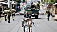 A 2015 file picture of boys walking behind patrolling soldiers in Bujumbura, Burundi. Burundian. Goran Tomasevic/Reuters
