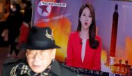 FILE PHOTO: A man walks past a TV screen broadcasting a news report on North Korea firing a ballistic missile into the sea off its east coast, at a railway station in Seoul, South Korea, February 12, 2017. REUTERS/Kim Hong-JI/File Photo
