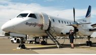 (FILES) A file photo taken on August 6, 2002, shows Captain Belinda Fleming standing in front of a Regional Express Airlines (REX) plane during the airline's launch at Sydney Airport. AFP / WILLIAM WEST