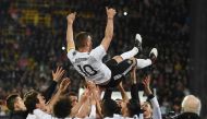 TOPSHOT - Teammates throw Germany's midfielder Lukas Podolski in the air after the friendly football match of Germany vs England in Dortmund, western Germany, on Marcht 22, 2017.   AFP / dpa / Bernd Thissen