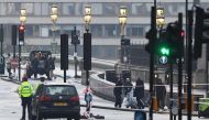 Security services staff collect debris left following the March 22 terror attack on Westminster Bridge in central London 23, 2017.   AFP / Justin TALLIS

