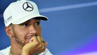 Mercedes' British driver Lewis Hamilton speaks during a press conference in Melbourne yesterday (left). Hamilton's helmet is also seen (inset).  