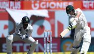 India's wicket keeper Wriddhiman Saha (L) watches as Australia's captain Steve Smith plays a shot during the first day of the fourth and last cricket Test match between India and Australia at the Himachal Pradesh Cricket Association Stadium in Dharamsala 