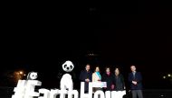 (L-R) WWF France president Pascal Canfin, French Ecology Minister Segolene Royal and Paris mayor Anne Hidalgo poses near the Eiffel Tower in Paris after it went dark for the Earth Hour environmental campaign on March 19, 2016. / AFP / THOMAS OLIVA