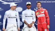 Mercedes' British driver Lewis Hamilton (C), teammate Mercedes' Finnish driver Valtteri Bottas (L) and Ferrari's German driver Sebastian Vettel (R) chat after the qualifying session at the Formula One Australian Grand Prix in Melbourne on March 25, 2017. 