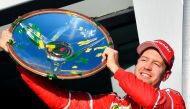 Ferrari's German driver Sebastian Vettel celebrates with the winner's trophy on the podium following his victory in the Australian Grand Prix in Melbourne on March 26, 2017.  AFP / SAEED KHAN