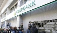 Members and supporters of the National corp political party erect a wall of concrete blocks and paint graffiti outside a branch of Sberbank, which is the local subsidiary of Russia's largest lender, during a protest in Kiev, Ukraine, March 13, 2017. REUTE