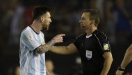Argentina's forward Lionel Messi (L) argues with first assistant referee Emerson Augusto de Carvalho at the end of their 2018 FIFA World Cup Russia South American qualifier football match against Chile, at the Monumental stadium in Buenos Aires, on March 