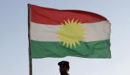 A Kurdish Peshmerga soldier holds a Kurdistan flag during a deployment in the area near the northern Iraqi border with Syria, which lies in an area disputed by Baghdad and the Kurdish region of Ninawa province, August 6, 2012. REUTERS/Azad Lashkari