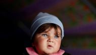 Displaced Iraqi baby who had fled her home is carried by her brother inside a tent in at Hammam al-Alil camp south of Mosul, Iraq March 29, 2017. REUTERS/Suhaib Salem
