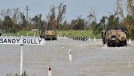 Army vehicles driving through floodwaters near the Queensland town of Bowen on March 29, 2017, after the area was hit by Cyclone Debbie.PHOTO: AFP.