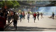 Protesters run from tear gas being fired by police during Irreecha, the religious festival in Bishoftu where at least 52 people died [Tiksa Negeri/Reuters]