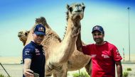 Qatar's Nasser Saleh Al Attiyah (right) and his co-driver Matthieu Baumel take selfies with a camel during the testing stage of the Abu Dhabi Desert Challenge yesterday. The Abu Dhabi Desert Challenge powered by Nissan fired into life with a short spectat
