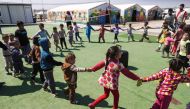 Displaced children who fled Mosul play outside of tents in a playground at Hasan Sham camp, 30 kilometres (20 miles) east of Mosul, on March 26, 2017. AFP / AHMAD GHARABLI
