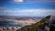 A general view shows the Spanish city of La Linea de la Concepcion (rear) and the tarmac of the Gibraltar International Airport (bottom L) while tourists stand on the top of the Rock (R) next to the European Union flag, in the British overseas territory o